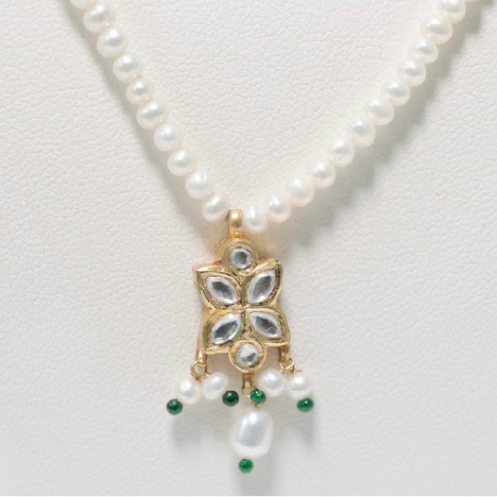 Pearl string with a gold pendent in 22 k gold with crystal .